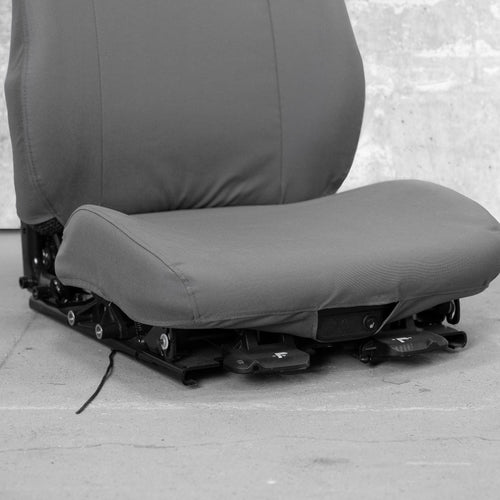 This is a close-up of the front seat bottom of a TigerTough heavy equipment seat cover. You can see how the seat cover works around the front seat controls.